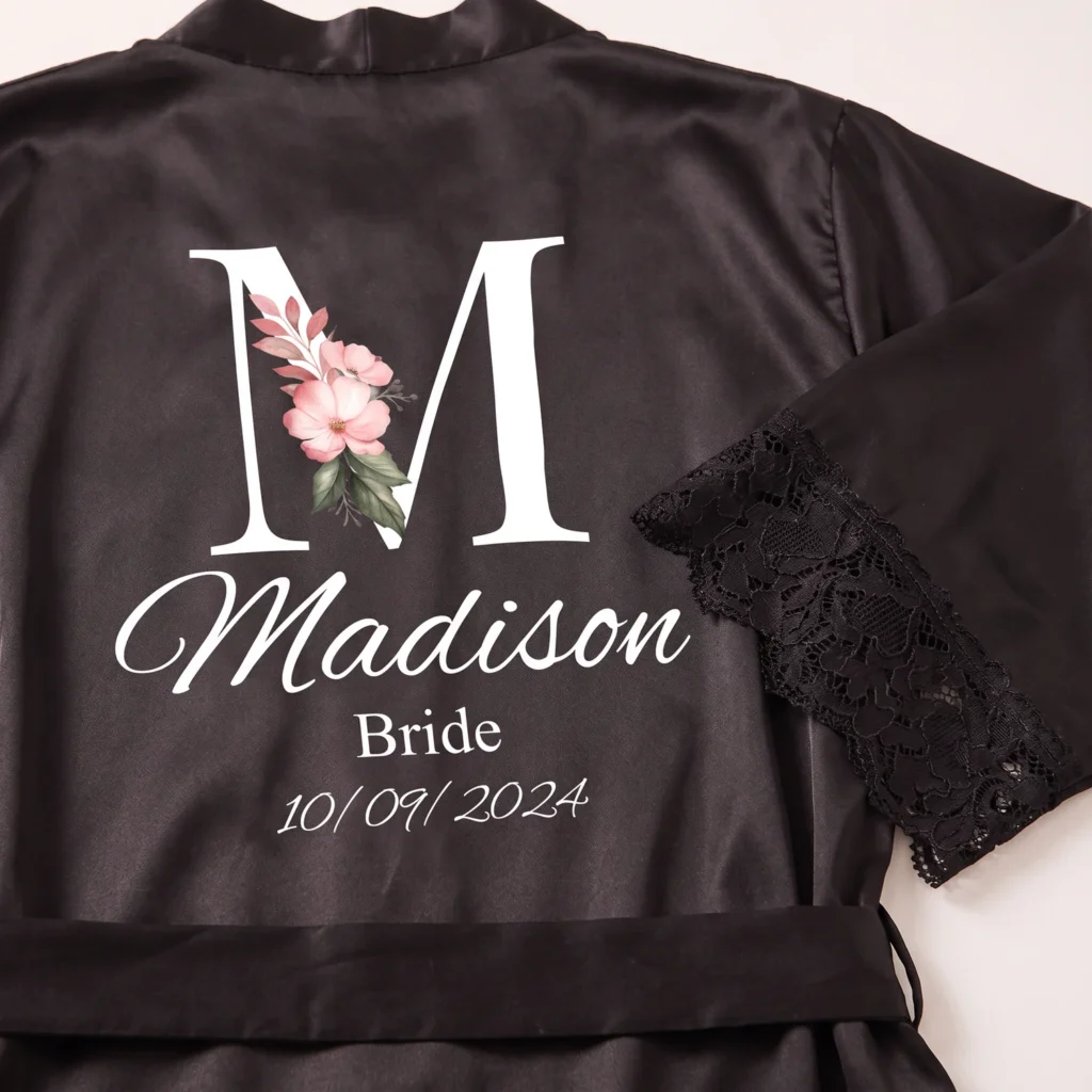 Close-up of the initial and name printed on a black satin robe