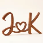 Dark wooden script initials joined by a heart, freestanding